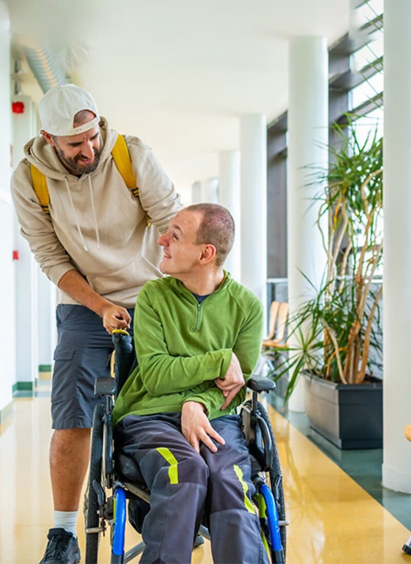 Caregiver assisting a resident in a wheelchair in a group home setting