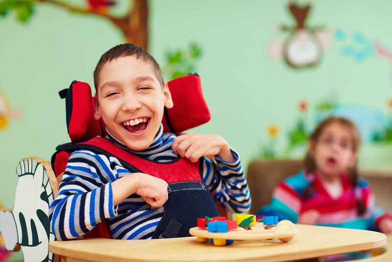 Child with developmental disabilities smiling in a care setting